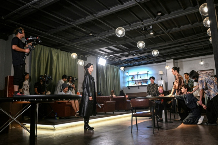 Des acteurs et l'équipe d'une mini-série chinoise tournent une scène dans un studio spécialisé à Shanghai, le 10 octobre 2025 ( AFP / Jade GAO )