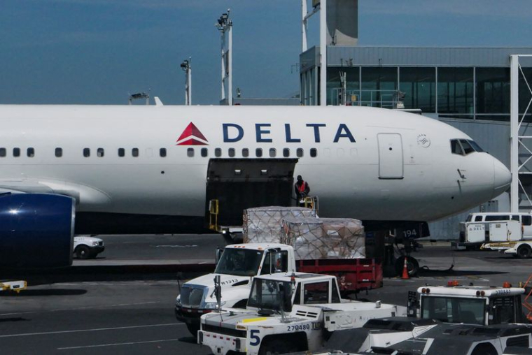 Un employé télécharge des colis dans un avion de Delta Air Lines à l'aéroport international John F. Kennedy dans le Queens, à New York