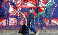 Une Iranienne passe devant un panneau anti-américain représentant des discussions Entre les deux pays, à Téhéran, le 26 février 2026 ( AFP / - )