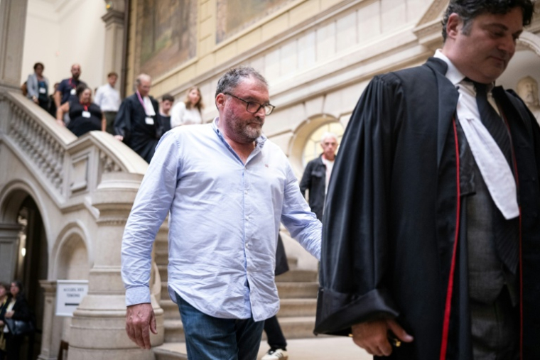 L'ex-anesthésiste Frédéric Péchier (au centre) marche derrière son avocat Me Randall Schwerdorffer, le 8 septembre 2025 à la cour d'assises de Besançon ( AFP / SEBASTIEN BOZON )