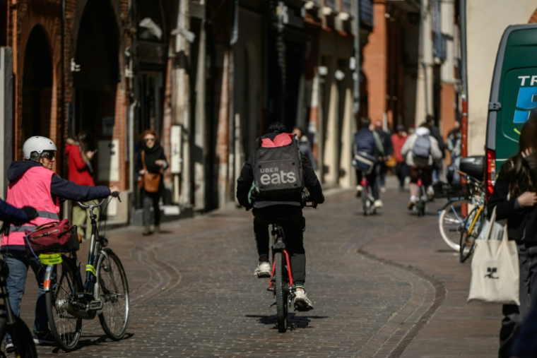 Un livreur Uber Eats à vélo dans une rue à Toulouse, le 18 mars 2025 ( AFP / Ed JONES )