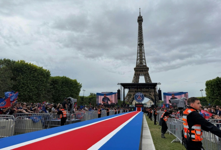 Des supporteurs du Paris Saint-Germain se rassemblent sur le Champs-de-Mars à Paris avant l'arrivée des joueurs sacrés champions d'Europe, le 31 mai 2026   ( AFP / Kenzo TRIBOUILLARD )
