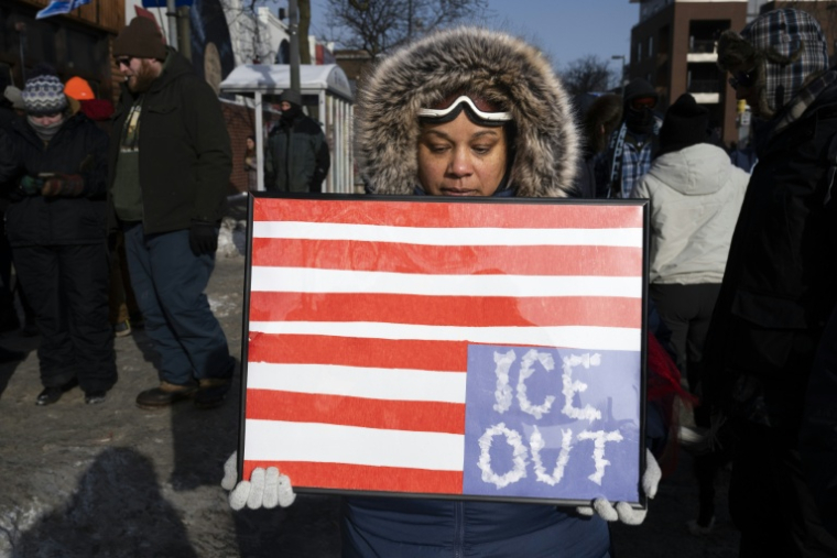 Une femme tient une pancarte devant le mémorial improvisé en hommage à Alex Pretti, à Minneapolis, dans le Minnesota, le 25 janvier 2026 ( AFP / ROBERTO SCHMIDT )