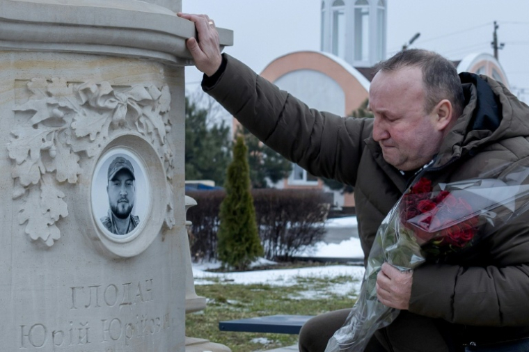 Le père du soldat ukrainien Iouriï Glodan, tué au combat en septembre 2023 près de Bakhmout, le 20 février 2026 sur la tombe de son fils à Odessa ( AFP / Oleksandr GIMANOV )