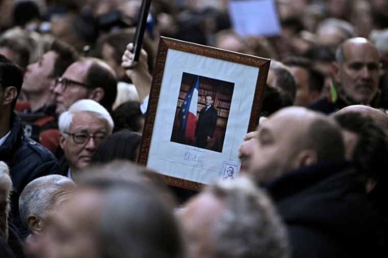 Des partisans de l'ancien président Nicolas Sarkozy rassemblés devant sa résidence avant son départ pour la prison de La Santé, le 21 octobre 2025 à Paris ( AFP / JULIEN DE ROSA )