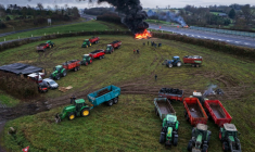 Des agriculteurs allument un feu alors qu'ils participent, avec leurs véhicules, à un blocage d'autoroute, à Poilley, dans l'ouest de la France, le 5 janvier 2026 ( AFP / Damien MEYER )