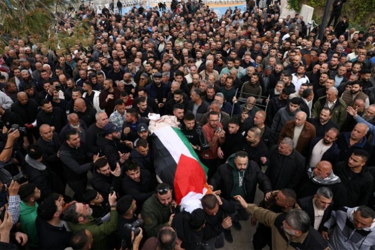 Une foule transporte le cercueil d'une des trois femmes tuées dans une frappe iranienne mortelle, le 19 mars 2026 à Beit Awa, en Cisjordanie occupée ( AFP / HAZEM BADER )
