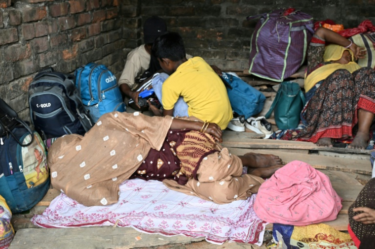Des migrants bangladais attendent de pouvoir franchir la frontière à Hakimpur, à 80 km de Calcutta (nord-est de l'Inde), le 28 mai 2026  ( AFP / Dibyangshu SARKAR )