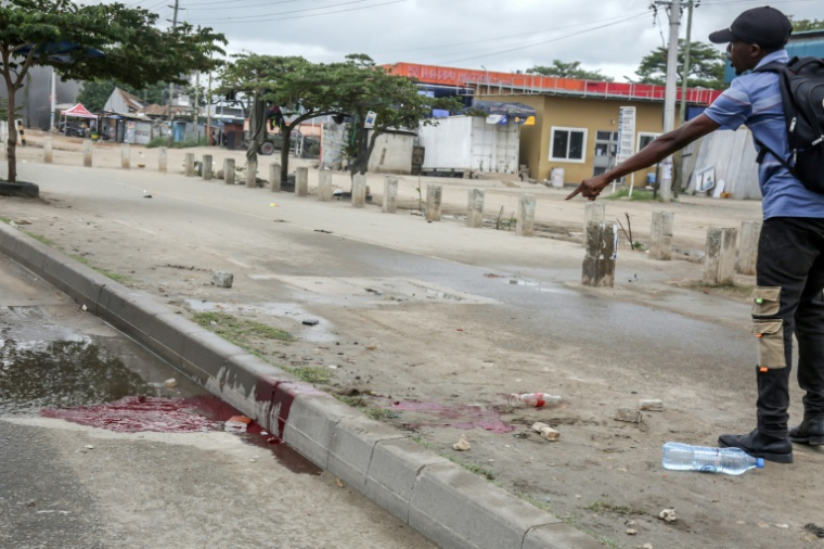 Un homme montre une mare de sang, le 29 octobre 2025,  dans une rue de Dar es Salaam, capitale économique de la Tanzanie  ( AFP / - )