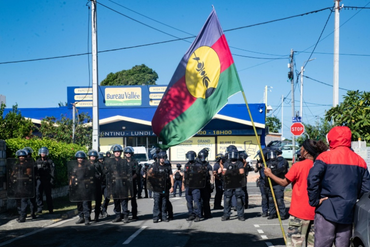 Des manifestants calédoniens indépendantistes font face à des gendarmes devant le siège de l'Union calédonienne  à Nouméa, le 19 juin 2024  ( AFP / Delphine Mayeur )