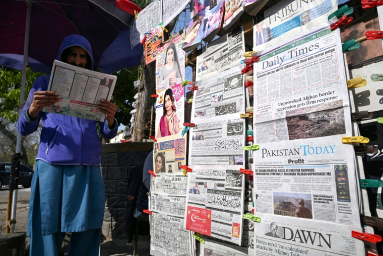 Un homme lit un journal relatant les affrontements transfrontaliers entre le Pakistan et l'Afghanistan, le 27 février 2026 à Islamabad, au Pakistan ( AFP / Farooq NAEEM )