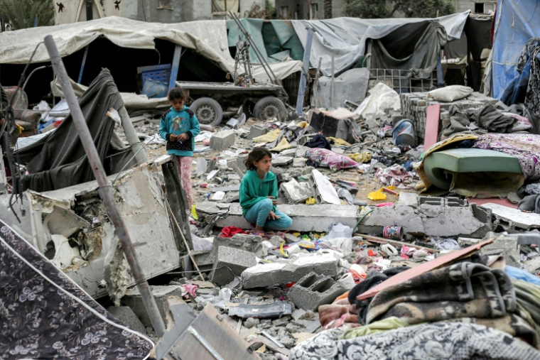 Des fillettes parmi les décombres, après des frappes aériennes israéliennes, à Deir el-Balah, dans la bande de Gaza, le 8 avril 2025 ( AFP / Eyad BABA )