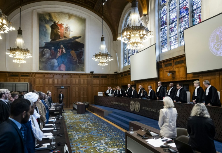 Les membres des délégations des Émirats arabes unis et du Soudan debout au début d'une audience devant la Cour internationale de justice à La Haye, le 10 avril 2025 aux Pays-Bas ( ANP / Remko de Waal )