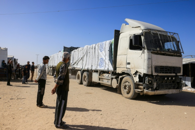 Des Palestiniens observent l'arrivée de camions transportant de l'aide humanitaire à Khan Younès, dans le sud de la bande de Gaza, après leur entrée par le côté égyptien du passage frontalier de Rafah, le 1er février 2026 ( AFP / Bashar Taleb )