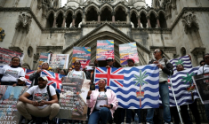 Des membres de la communauté chagossienne sont rassemblés devant la Haute Cour de Londres pour protester contre la signature de l'accord de restitution par le Royaume-Uni des îles Chagos à Maurice.  ( AFP / HENRY NICHOLLS )
