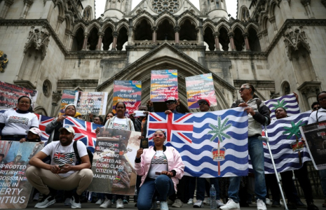Des membres de la communauté chagossienne sont rassemblés devant la Haute Cour de Londres pour protester contre la signature de l'accord de restitution par le Royaume-Uni des îles Chagos à Maurice.  ( AFP / HENRY NICHOLLS )