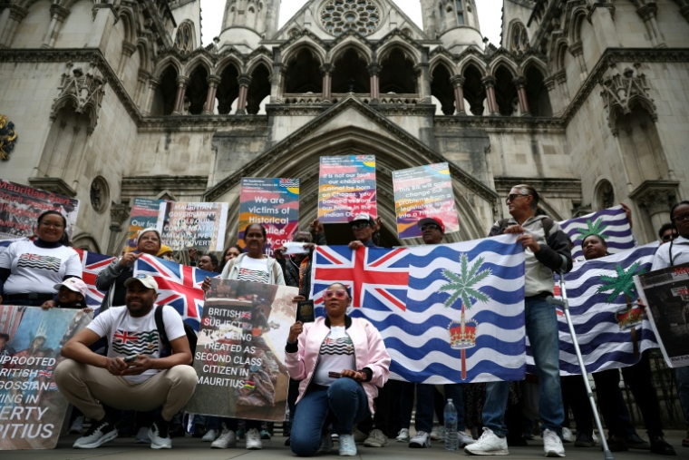 Des membres de la communauté chagossienne sont rassemblés devant la Haute Cour de Londres pour protester contre la signature de l'accord de restitution par le Royaume-Uni des îles Chagos à Maurice. ( AFP / HENRY NICHOLLS )