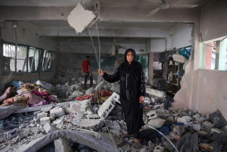 Une femme au milieu des décombres dans une école où se réfugiaient des déplacés palestiniens, visée par une frappe israélienne à Gaza-ville, le 26 mai 2025 ( AFP / Omar AL-QATTAA )