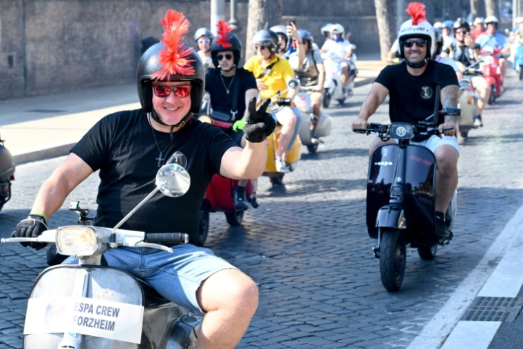 Des passionnés de Vespa participent à la parade des Vespa World Days, marquant le 80e anniversaire de la célèbre marque italienne de scooters, le 27 juin 2026 à Rome  ( AFP / Alberto PIZZOLI )