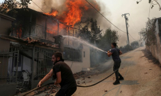 Des volontaires tentent d'éteindre un incendie dans une maison près d'Athènes, en Grèce