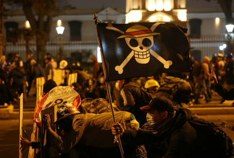 Des manifestants brandissant un drapeau du manga "One Piece" affrontent les forces antiémeutes lors d'une manifestation contre le président par intérim du Pérou, José Jeri, à Lima, le 15 octobre 2025 ( AFP / Hugo CUROTTO )