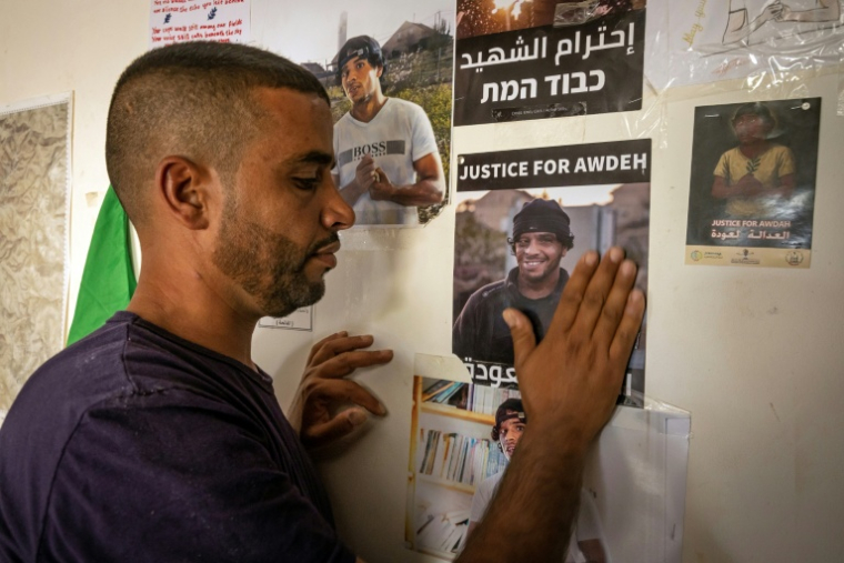Le chef de la communauté bédouine du village d'Oum al-Kahir, Khalil Hathaleen, regarde une affichette montrant son frère Awdah, abattu en juillet 2025 alors qu'il filmait la démolition de champs d'oliviers, le 2 novembre 2025 à Oum al-Khair ( AFP / FADEL SENNA )