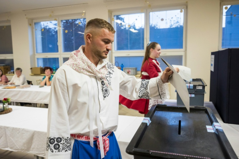 Des électeurs en costume traditionnel votent lors des législatives à Sardice, le 3 octobre 2025 en République tchèque ( AFP / Radek Mica )