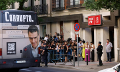 Un bus affichant le portrait de Pedro Sanchez et la mention "corrompu" passe devant le siège du PSOE à Madrid le 5 juillet 2025  ( AFP / OSCAR DEL POZO )