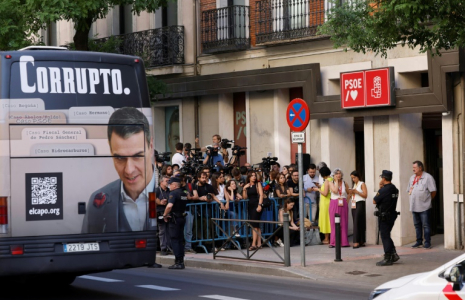 Un bus affichant le portrait de Pedro Sanchez et la mention "corrompu" passe devant le siège du PSOE à Madrid le 5 juillet 2025  ( AFP / OSCAR DEL POZO )