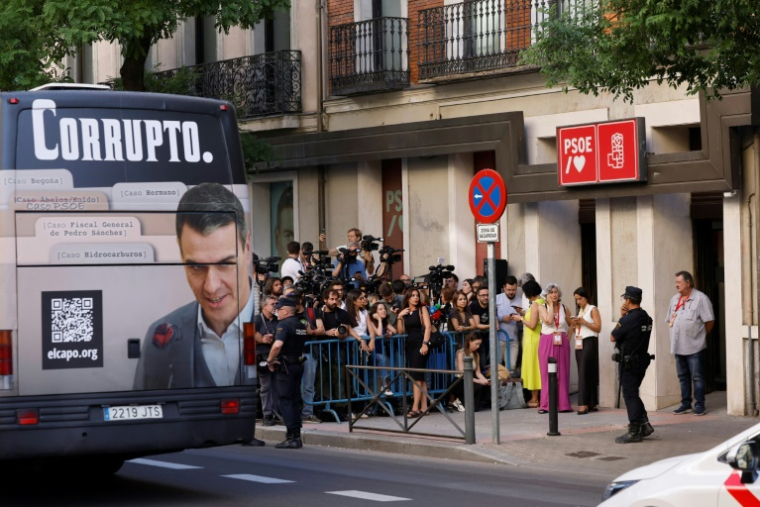 Un bus affichant le portrait de Pedro Sanchez et la mention "corrompu" passe devant le siège du PSOE à Madrid le 5 juillet 2025 ( AFP / OSCAR DEL POZO )