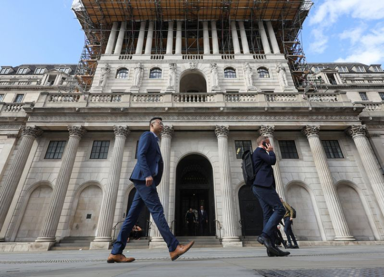 Des passants défilent devant le bâtiment de la Banque d'Angleterre à Londres.