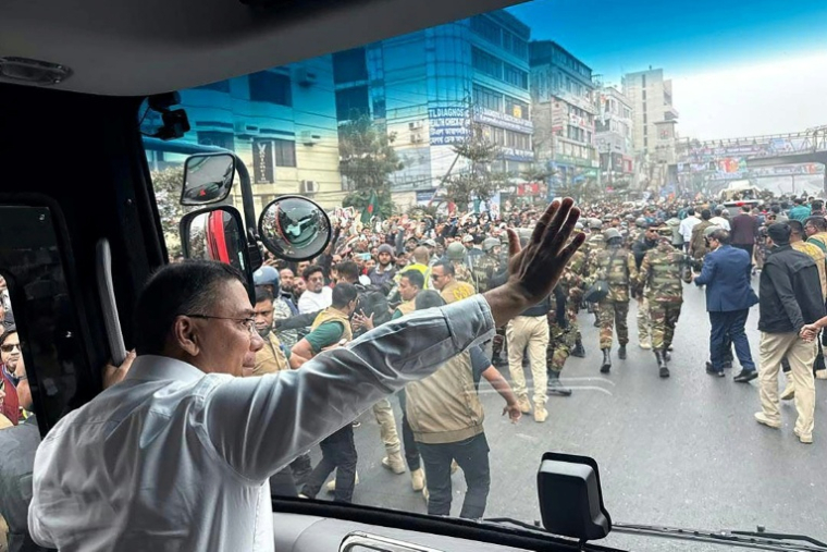 Photo prise et diffusée le 25 décembre 2025 par la cellule médias du Parti nationaliste du Bangladesh (BNP) sur sa page Facebook officielle, montrant le président par intérim du BNP, Tarique Rahman (c), saluant ses partisans depuis un bus à son arrivée à Dacca ( cellule médias du Parti nationaliste du Bangladesh / - )