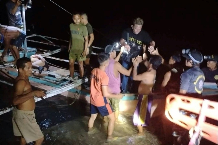 Cette photo fournie par la garde côtière philippine, prise le 9 septembre 2026 et reçue le 10 septembre 2026, montre des pêcheurs bénévoles venant en aide aux survivants du ferry qui a pris feu au large de Palawan, dans l'ouest des Philippines ( Philippine Coast Guard (PCG) / - )
