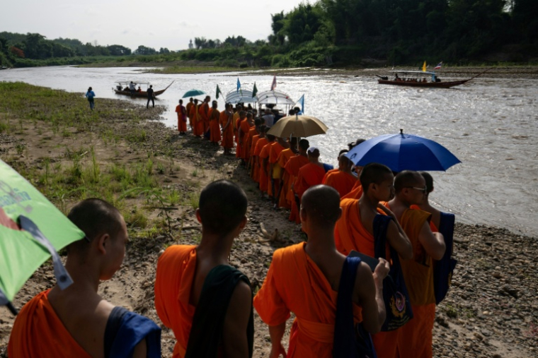 Des moines bouddhistes participent à une marche le long de la rivière Kok, le 5 juin 2026 près de Chiang Rai (  / Lillian SUWANRUMPHA )