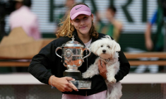La Russe Mirra Andreeva pose avec son trophée de Roland-Garros et son chien, le 6 juin 2026 ( AFP / Dimitar DILKOFF )