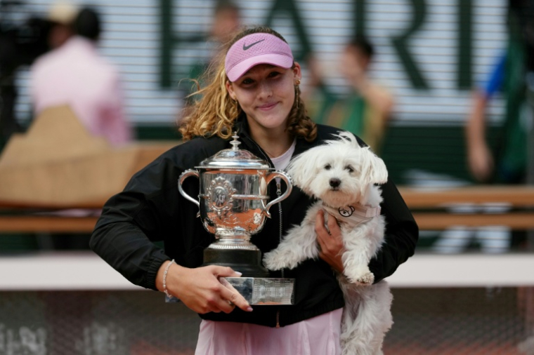 La Russe Mirra Andreeva pose avec son trophée de Roland-Garros et son chien, le 6 juin 2026 ( AFP / Dimitar DILKOFF )