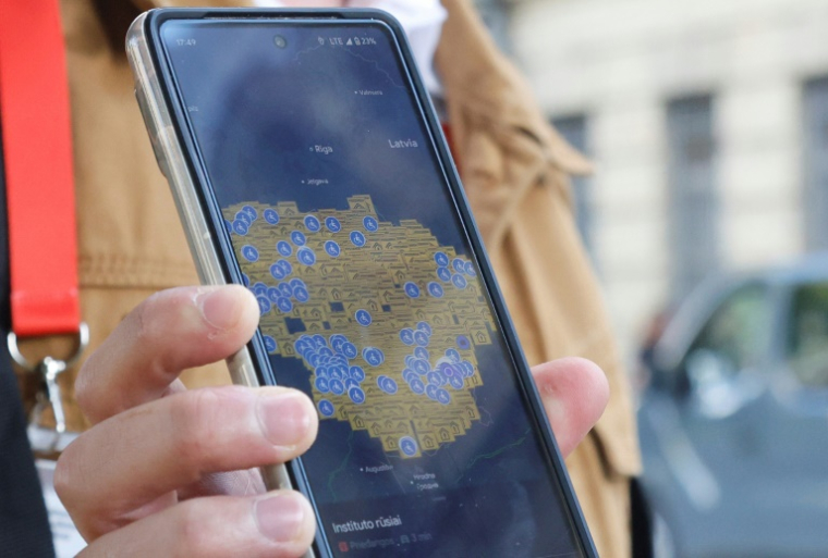 Un bénévole de la protection civile en Lituanie montre une carte du pays affichant les abris prévus en cas de "situations extrêmes", à Vilnius le 21 août 2025 ( AFP / Petras Malukas )