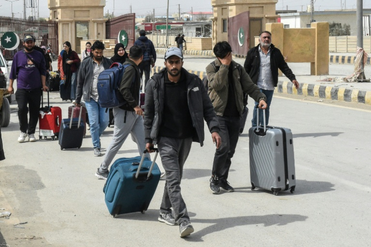 Des ressortissants pakistanais traversent la frontière de Taftan, au Pakistan, après leur retour d’Iran, le 2 mars 2026, sur fond de frappes américaines et israéliennes en cours contre l’Iran ( AFP / Banaras KHAN )