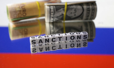 Photo d'illustration montrant des billets de banque en euros et en dollars et le mot "Sanctions" placés sur le drapeau russe
