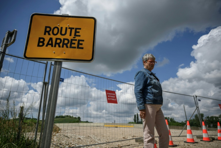 Marie-Claude Amand, habitante de la commune de Saint-Germain-des-Prés, devant la route barrée du chantier de construction de l'A69, le 7 mai 2025 dans le Tarn ( AFP / Ed JONES )