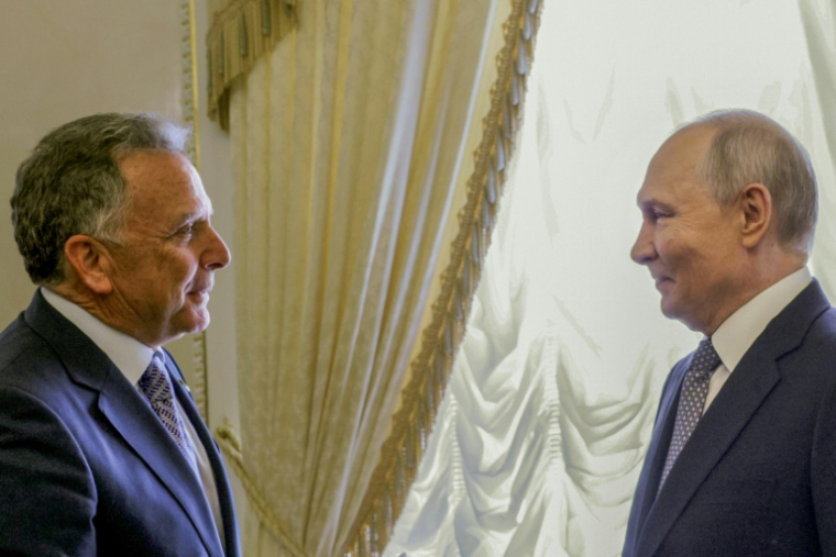 Sur cette photo de groupe diffusée par l'agence d'État russe Sputnik, le président russe Vladimir Poutine (D) salue l'envoyé spécial américain Steve Witkoff lors de leur rencontre à Saint-Pétersbourg le 21 octobre 2026 ( POOL / Gavriil GRIGOROV )