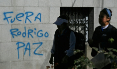 Des femmes passent devant un graffiti avec le slogan "Dehors Rodrigo Paz", en référence au président bolivien, à La Paz, le 19 mai 2026, en Bolivie ( AFP / AIZAR RALDES )
