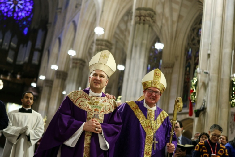 Le cardinal Timothy Dolan (droite) et son successeur à la tête de l'archidiocèse de New York, Mgr Ronald Hicks, lors d'une messe en la cathédrale Saint-Patrick à New York le 18 décembre 2025 ( AFP / CHARLY TRIBALLEAU )