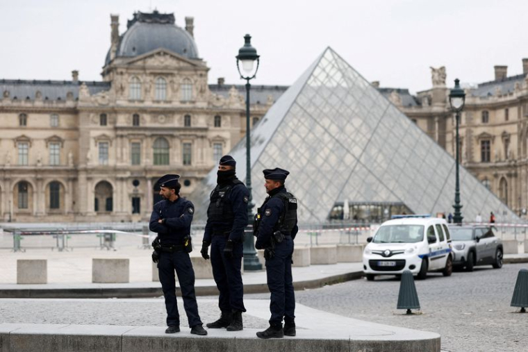 La police se tient près de la pyramide du musée du Louvre après des informations faisant état d'un vol, à Paris