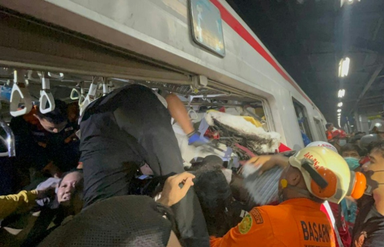 Des secouristes sur le site où une locomotive de train de voyageurs a percuté le wagon arrière d'un train de banlieue à la gare de Bekasi Timur, le 28 avril 2026 à Bekasi, en Indonésie ( Jakarta Search and Rescue Office / - )