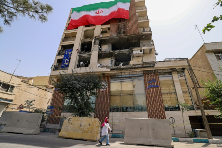 Un immeuble détruit par une frappe israélienne recouvert du drapeau iranien, à Téhéran le 25 juin 2025 ( AFP / ATTA KENARE )