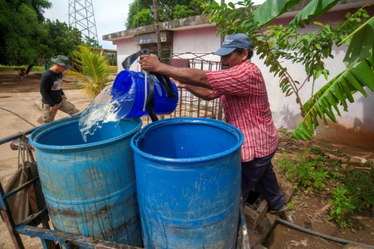 Un homme remplit un fût d'eau dans un quartier de Maracaibo, dans l'État de Zulia, au Venezuela, le 21 juin 2025 ( AFP / Alejandro Paredes )