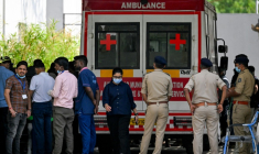 Des policiers et des membres du personnel médical près d'une ambulance stationnée devant une morgue d'hôpital à Ahmedabad, le 15 juin 2025 ( AFP / Punit PARANJPE )