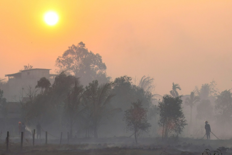 Des pompiers et des habitants luttent contre des feux de forêt dans une  fumée épaisse, le 21 octobre 2026 à Banjarbaru, dans la province du Kalimantan du Sud, le 21 octobre 2026 en Indonésie ( AFP / MUDA SAGALA )