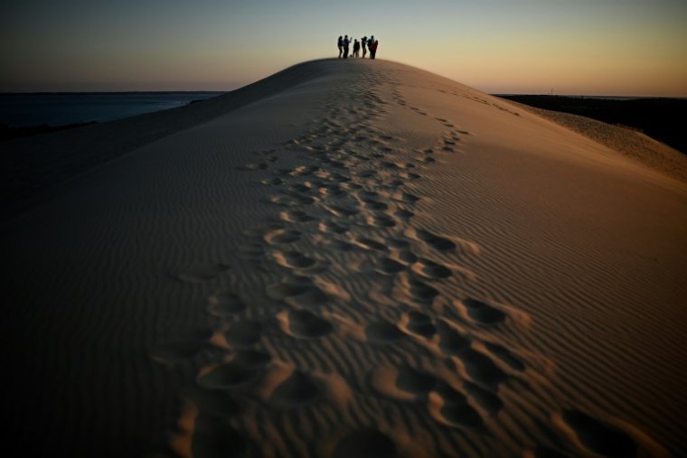 Des visiteurs au sommet de la dune du Pilat, le 10 avril 2025 à La Teste-de-Buch, en Gironde ( AFP / Christophe ARCHAMBAULT )